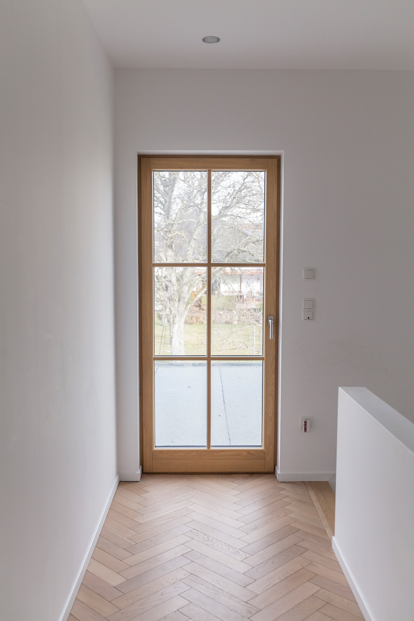 Interior con ventana de madera de roble en el rellano de una escalera