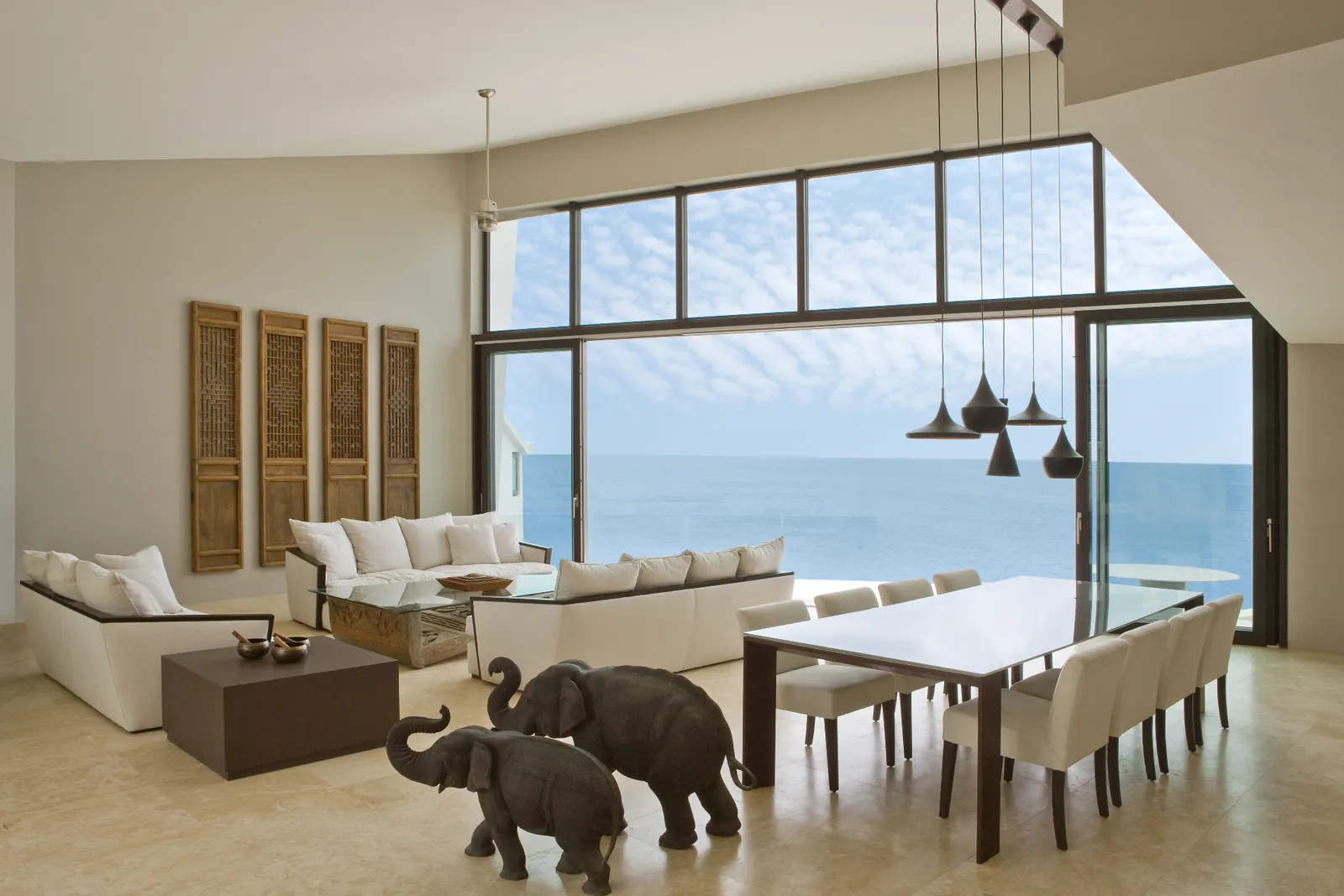 Gran fachada acristalada de construcción poste y viga con vistas al mar