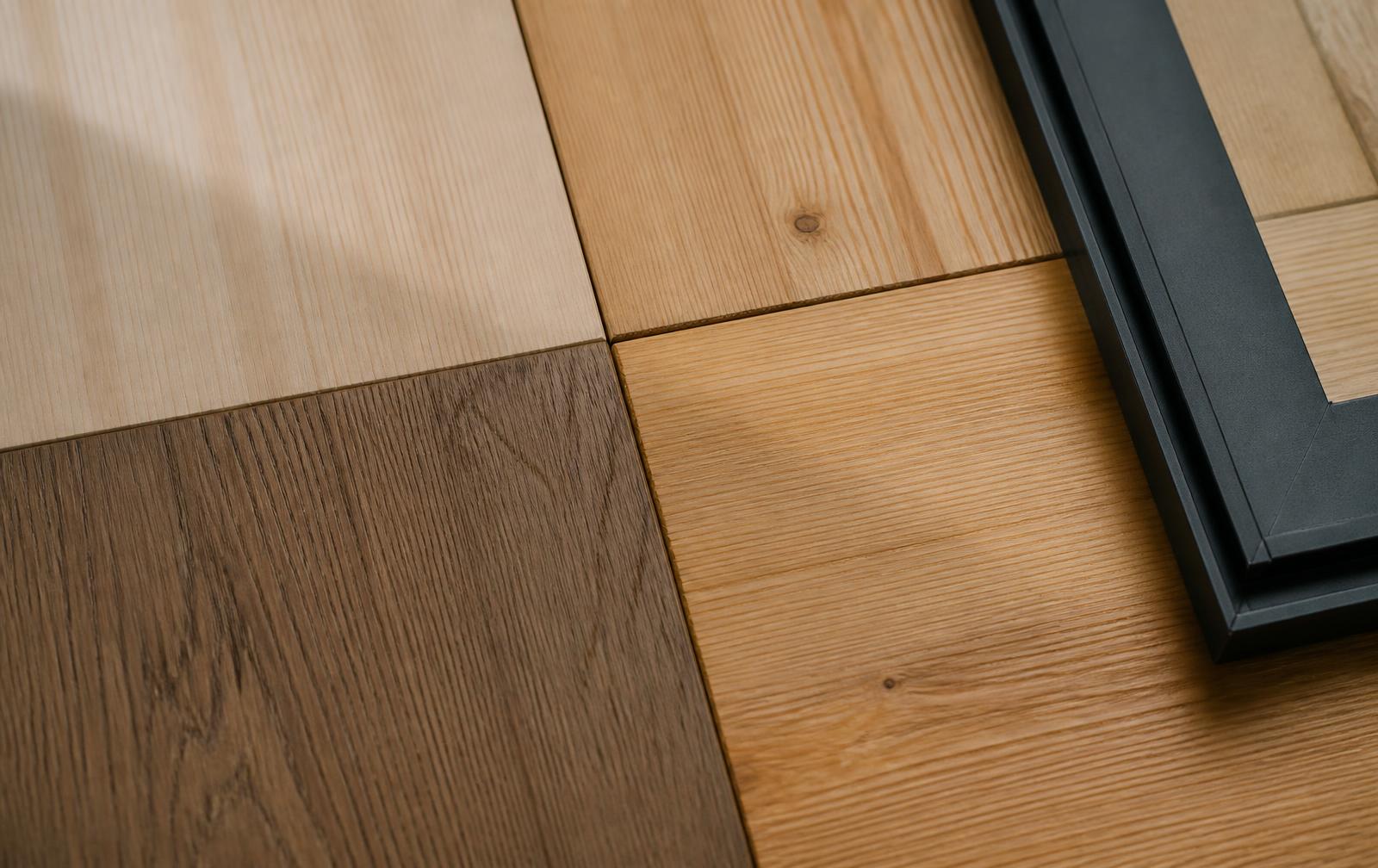 Muestras de madera en distintos acabados junto a un perfil de aluminio