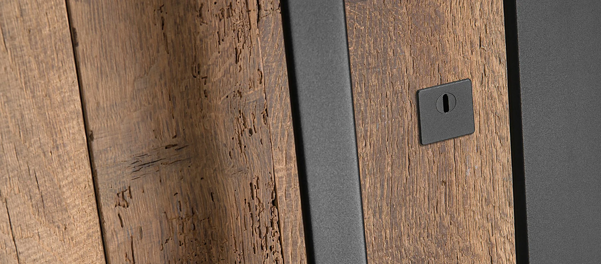 Detalle de puerta de entrada de madera veterana con marco de aluminio lacado en oscuro