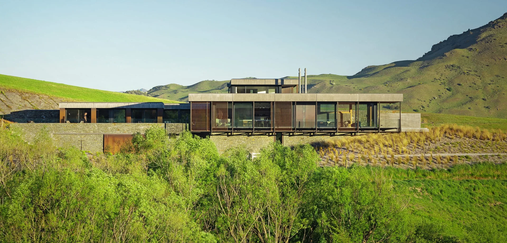 Vivienda en una colina con fachada acristalada SKYWALL al atardecer